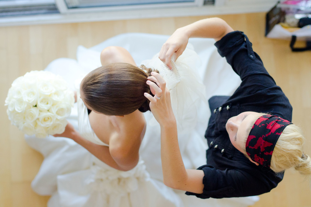 hairstylist putting in the brides veil